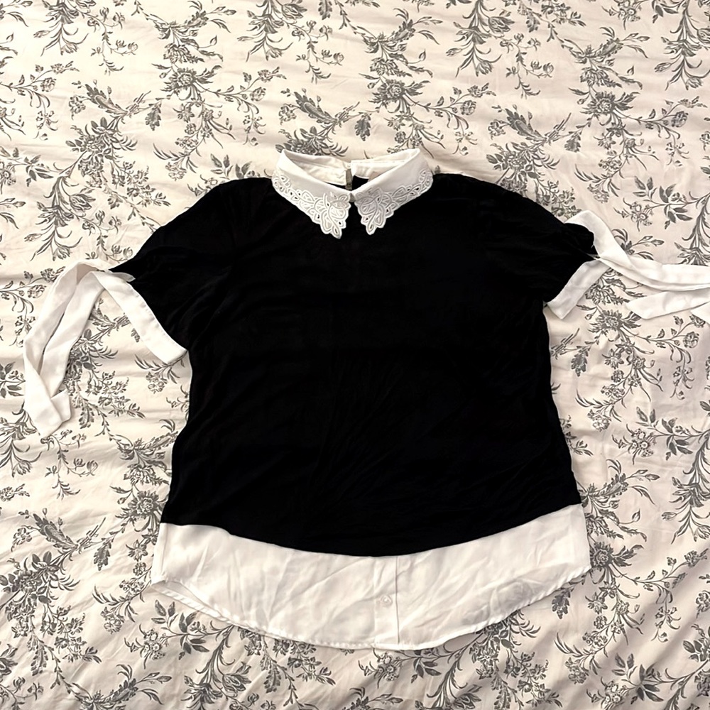 Black with white blouse with tie sleeves and collar.
